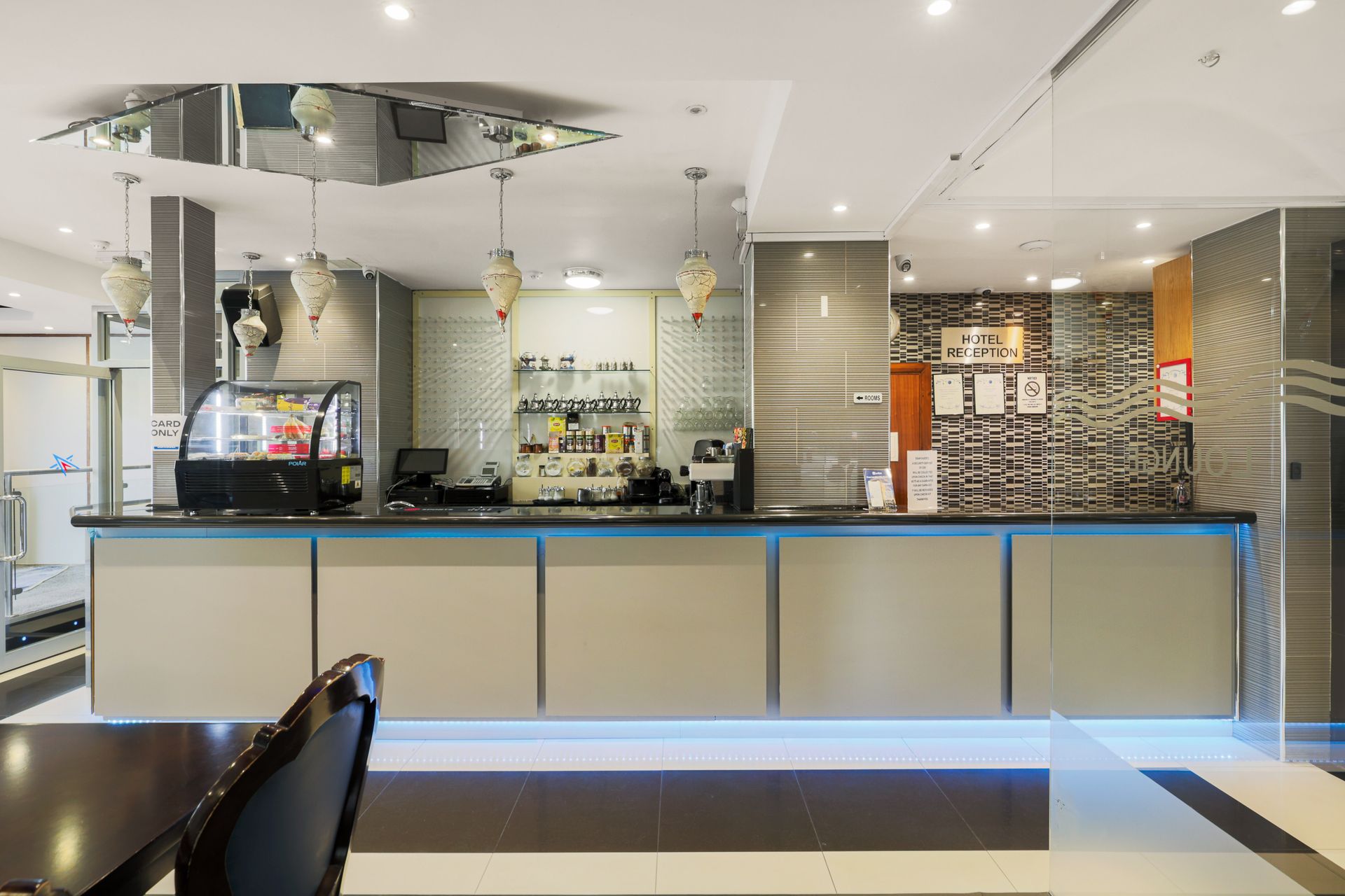The front desk of a hotel with a clock on the wall.