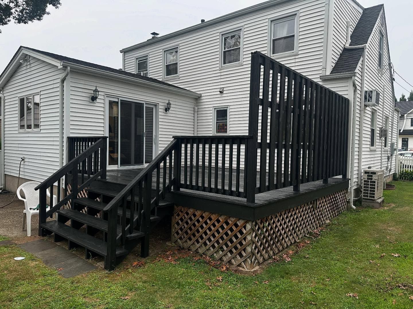 White house exterior with black porch and wheelchair-accessible ramp and steps