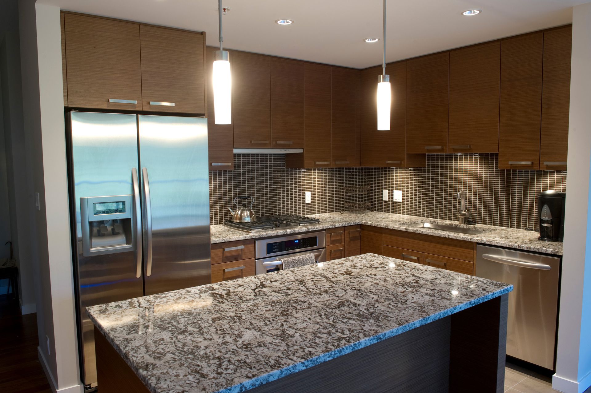 A kitchen with granite counter tops and stainless steel appliances.