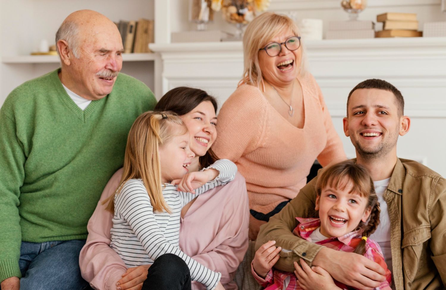 Family of five smiling together on a couch in a bright living room