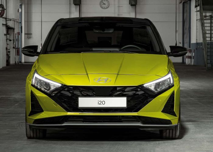A yellow hyundai i20 is parked in a garage.