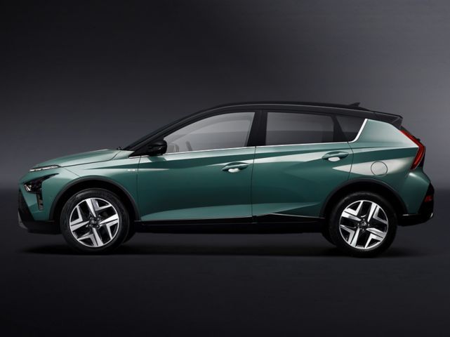 A green car with a black top is sitting on a black surface.
