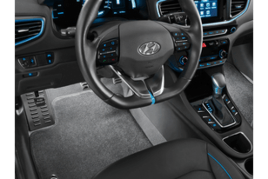 The interior of a car with a steering wheel and a dashboard.