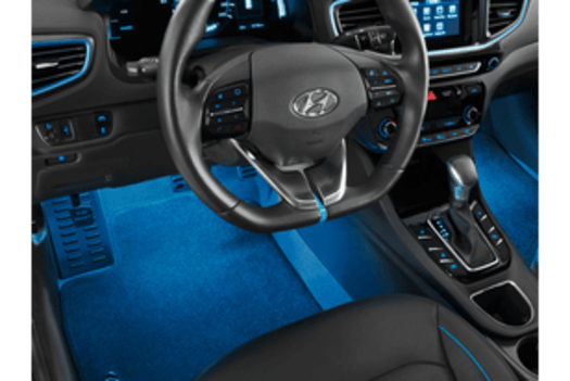 The interior of a car with blue lights on the floor.