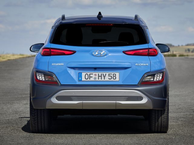 A blue hyundai kona is parked on the side of a road.