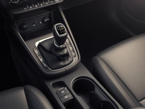 A close up of a car 's shifter and cup holder