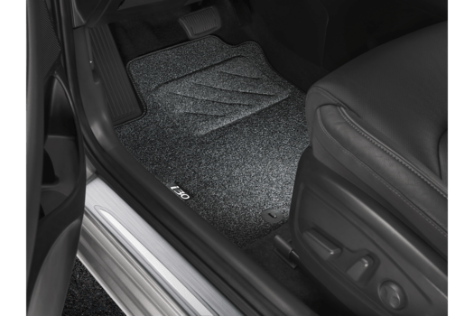 The inside of a car with a black seat and a black floor mat.