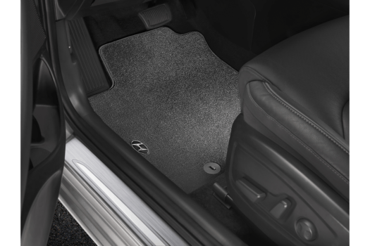 The inside of a car with a set of black floor mats.