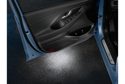 A blue car with the door open and a light on the door.