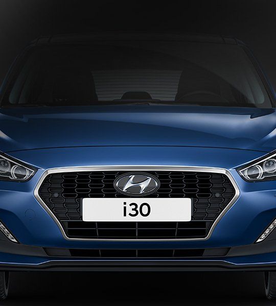 The front of a blue hyundai i30 is shown on a black background. 
