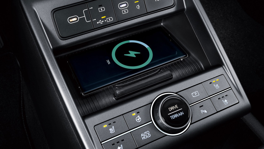 A wireless charger is sitting on top of a car dashboard. hyundai kona hybrid
