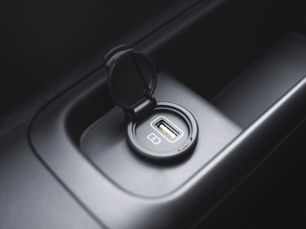 A close up of a car door with a usb port. Staria