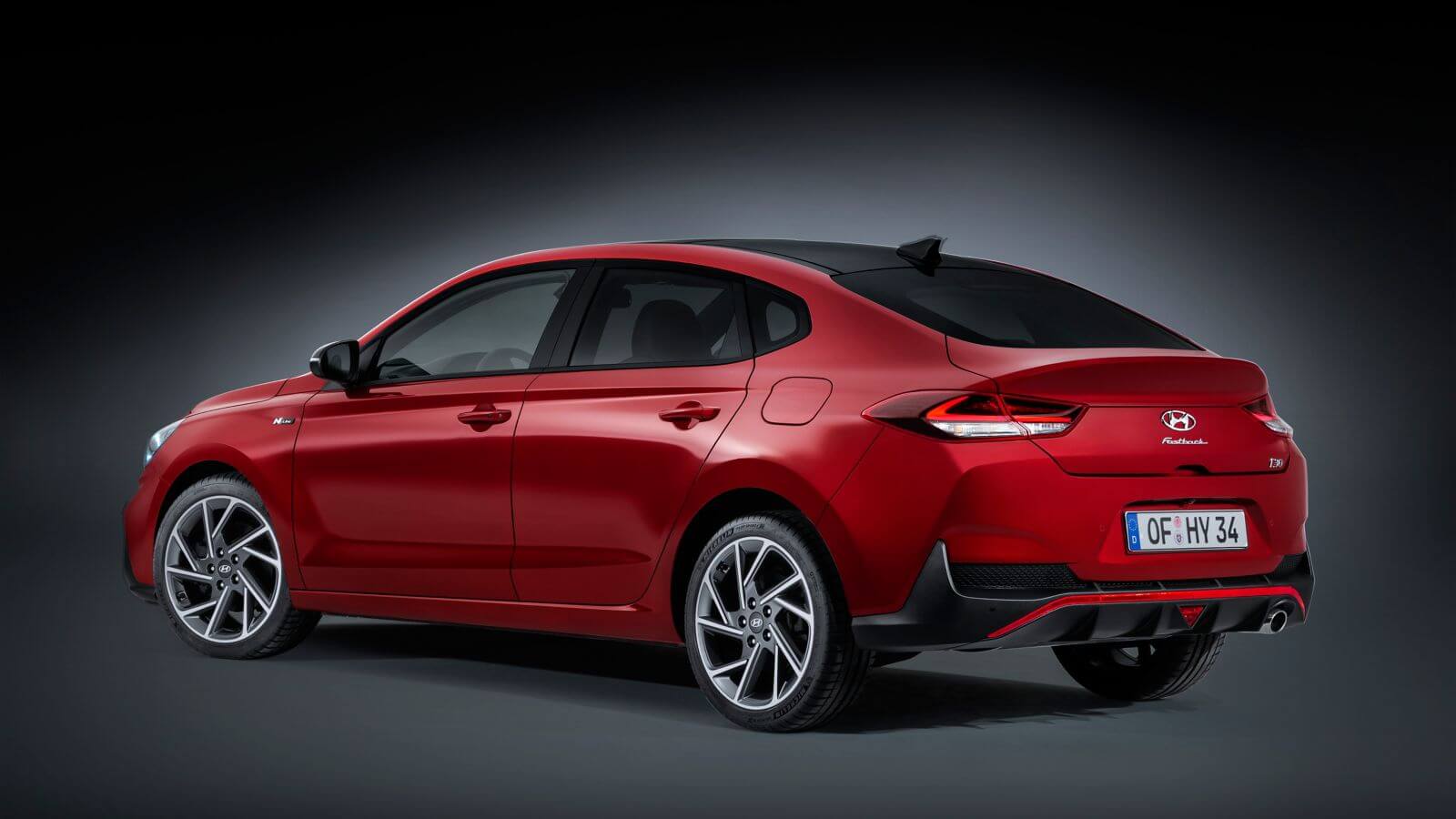 A red car is parked on a black background.