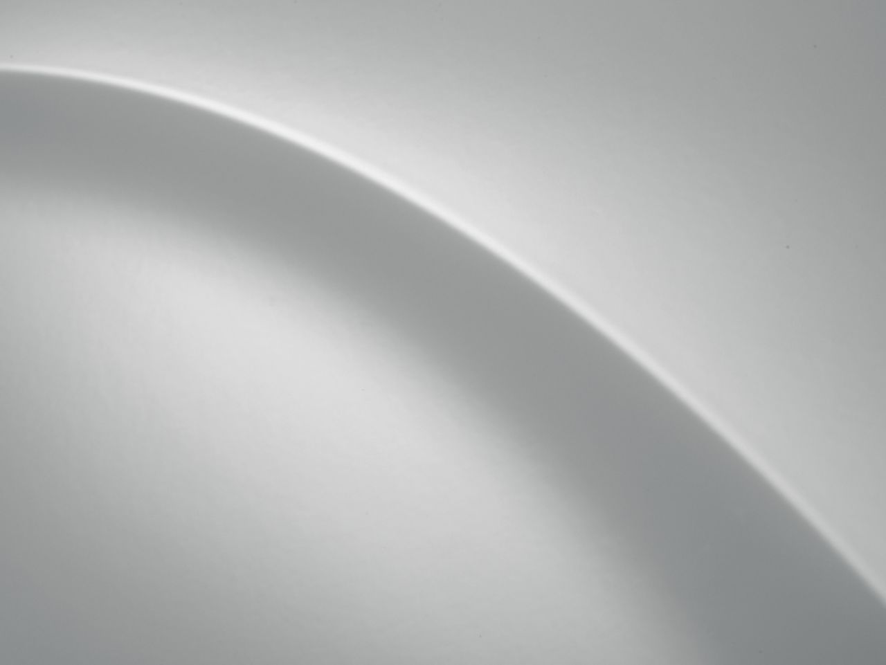 A close up of a white surface with a shadow on it. Staria