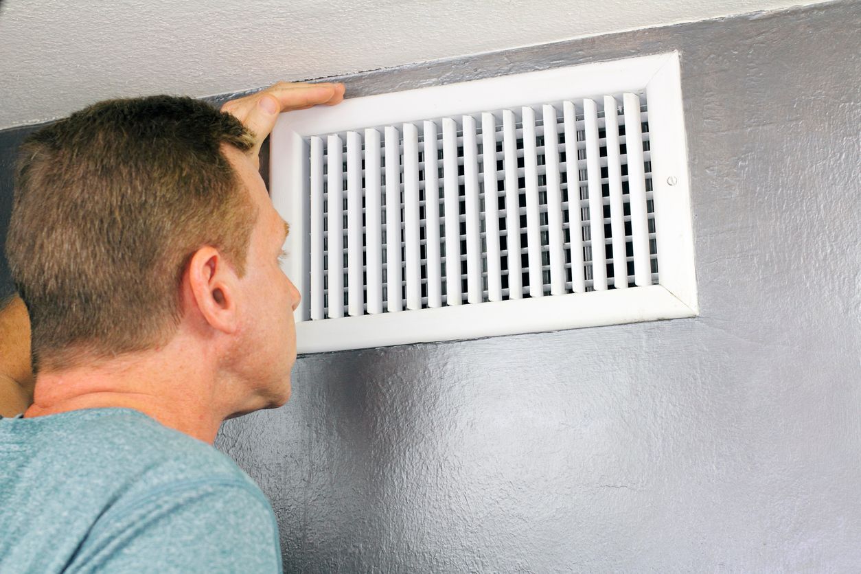 Technician cleaning air ducts in a residential home to improve indoor air quality in Fairport.