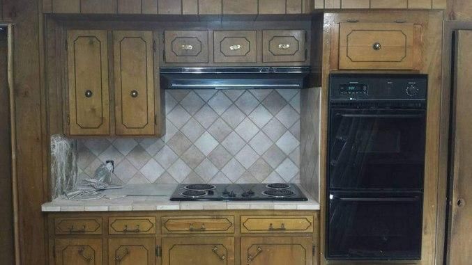 A kitchen with wooden cabinets and a stove top oven