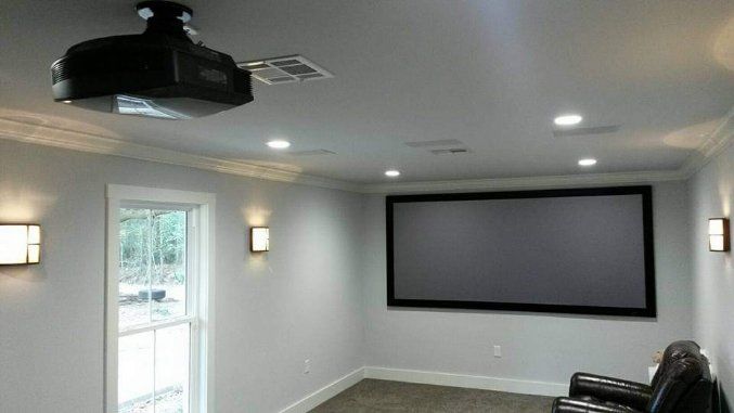 A home theater with a projector and a large screen.