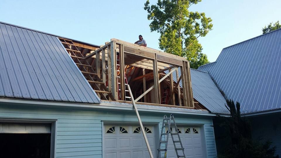 A man is working on the roof of a house.