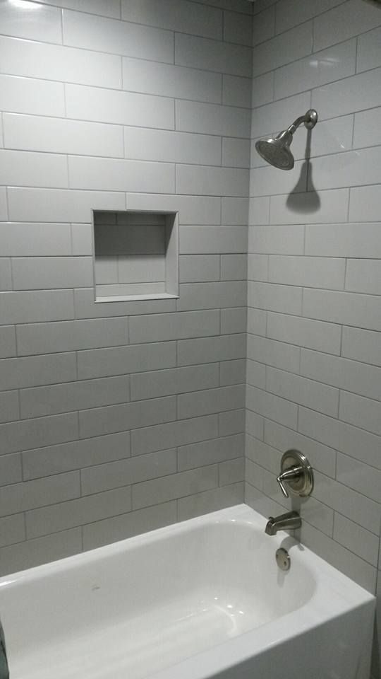 There is a bathtub in the shower with a shower head.