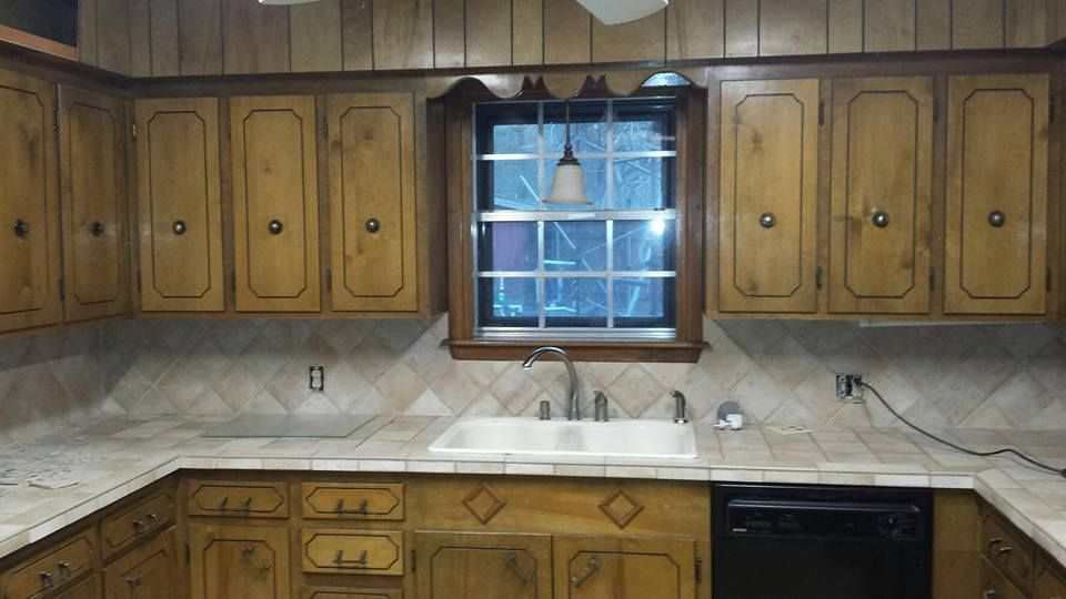 A kitchen with wooden cabinets a sink and a window