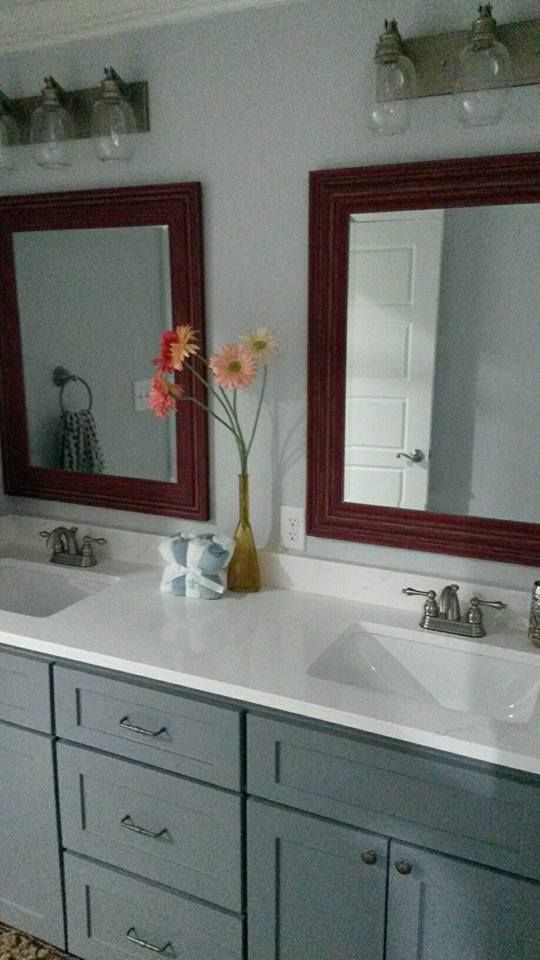A bathroom vanity with two sinks and two mirrors