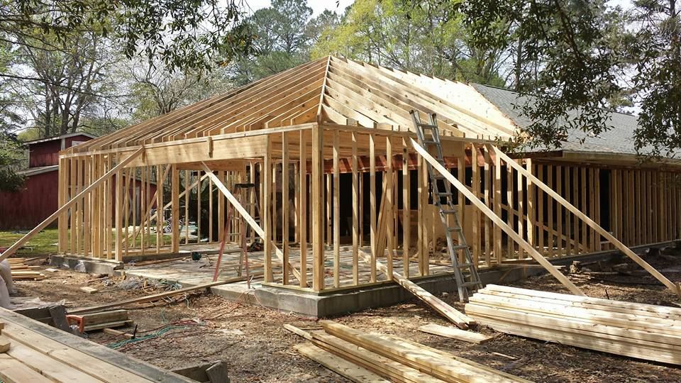 A house is being built out of wood in a yard.