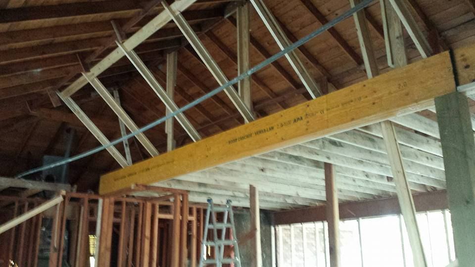 A wooden beam is hanging from the ceiling of a building under construction.