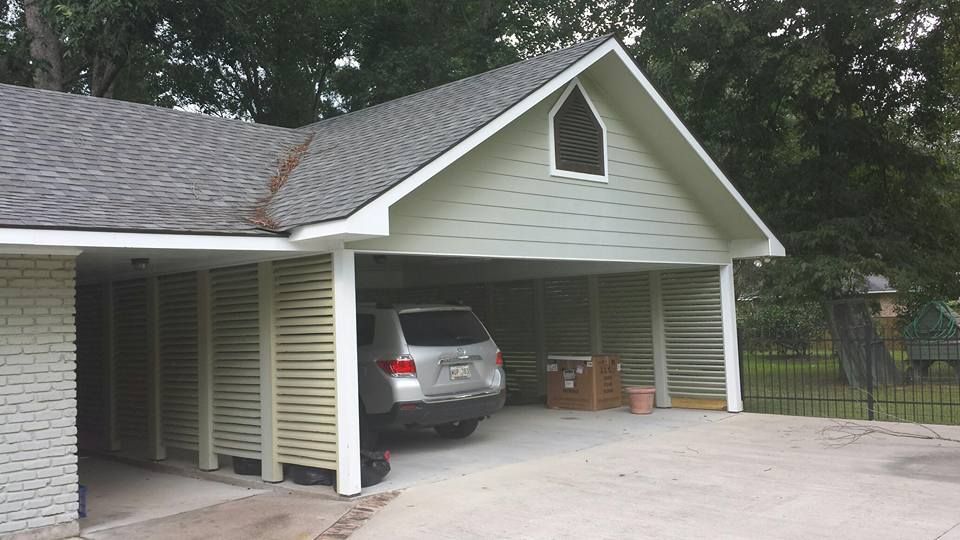 A car is parked in a carport under a house