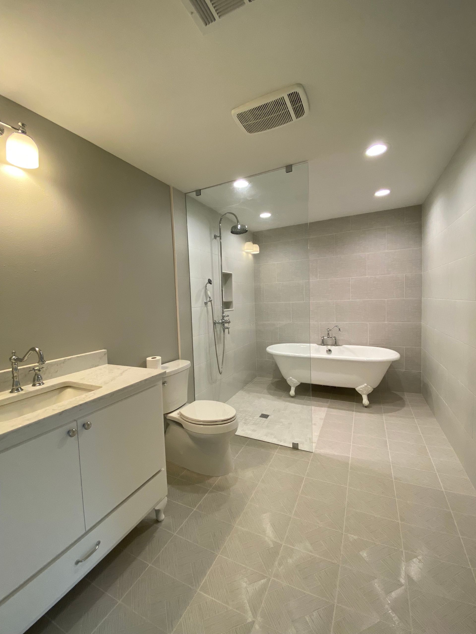 A bathroom with a tub , toilet , sink and shower.