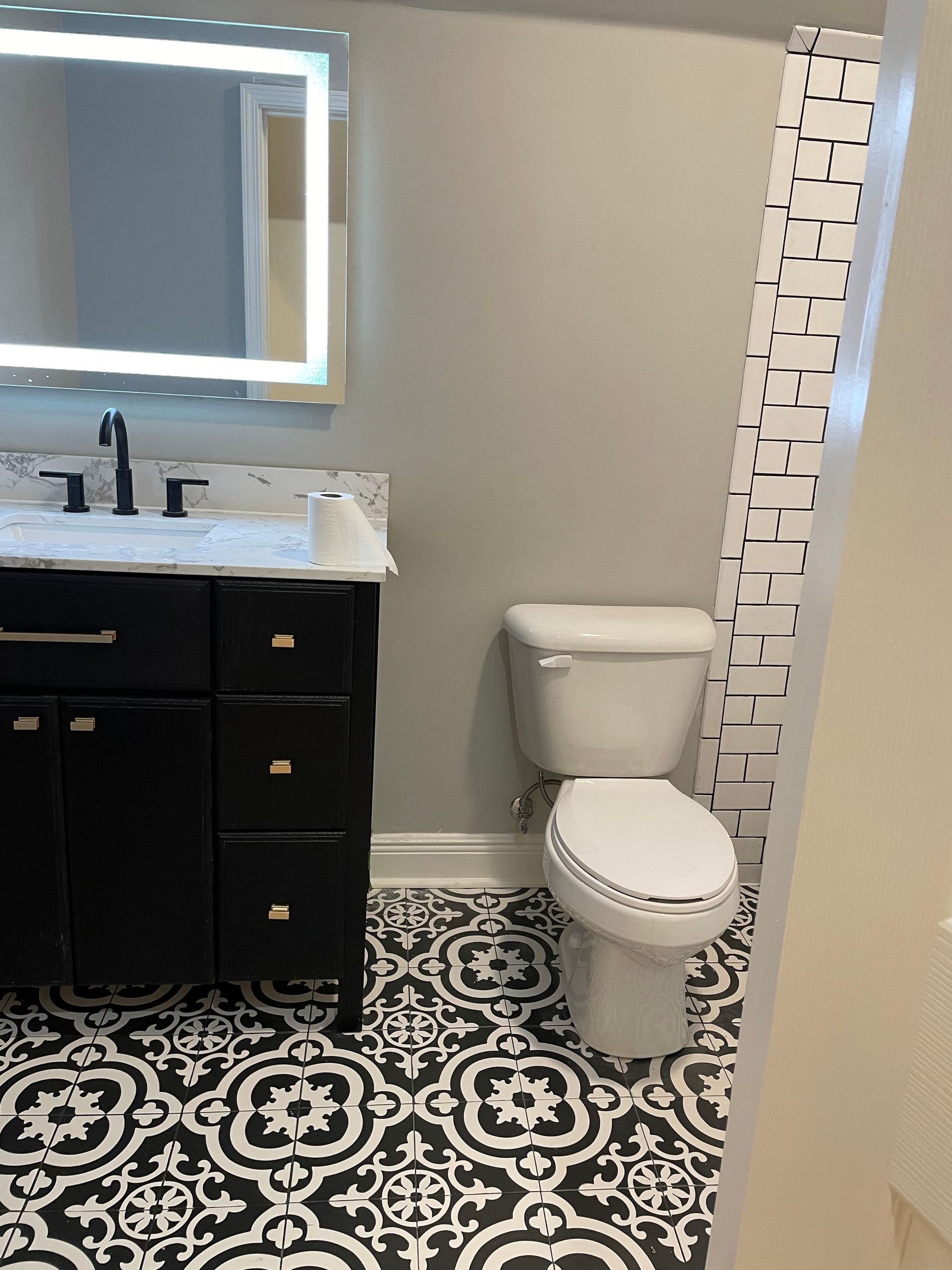 A bathroom with a toilet , sink , mirror and shower curtain.