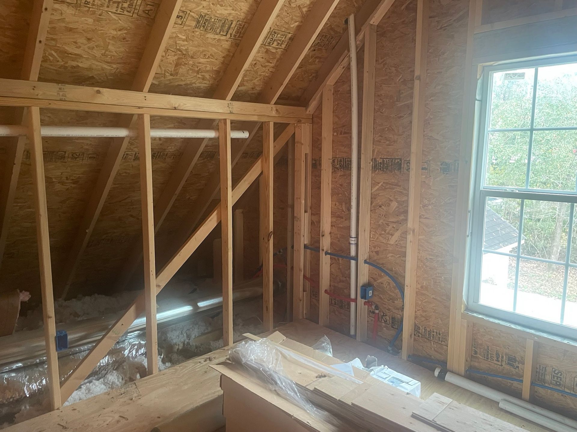 There is a window in the attic of a house under construction.