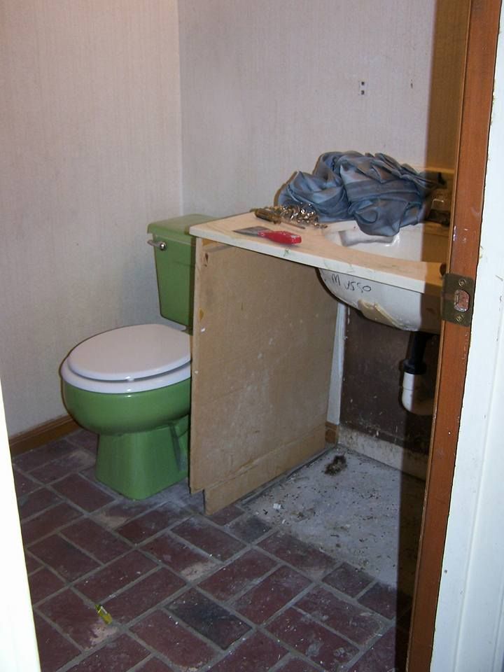 A bathroom with a green toilet and a sink