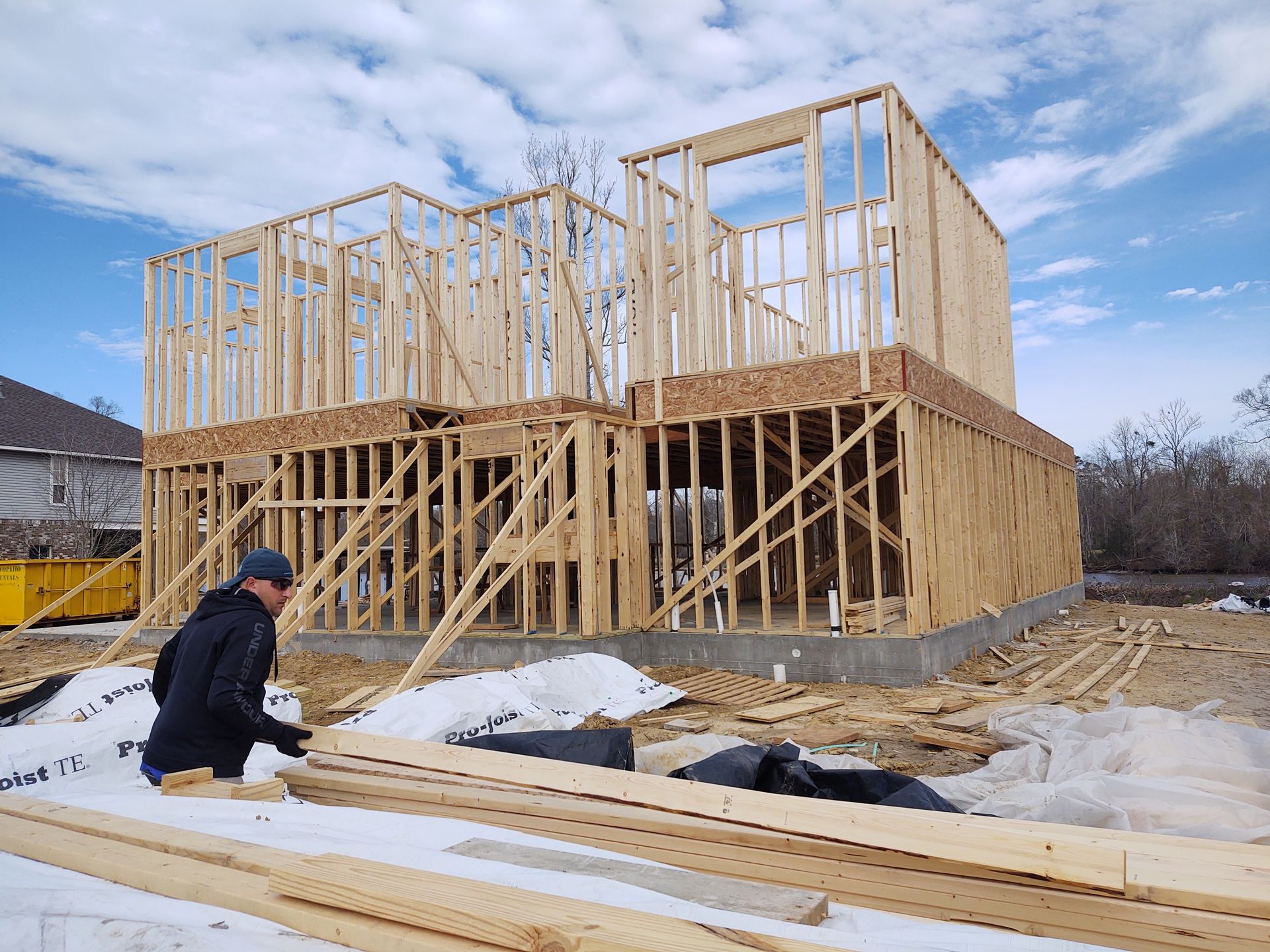A man is standing in front of a house that is being built.