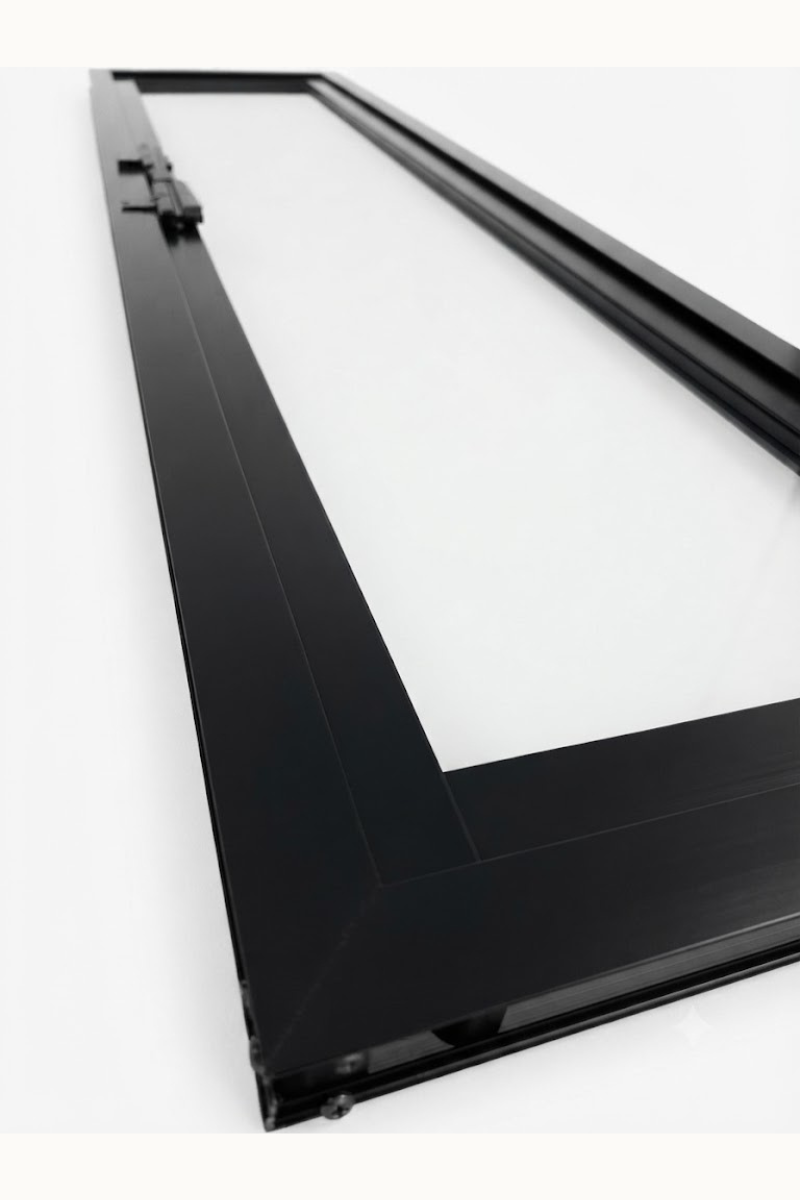 Inserto de chimenea rectangular con marco negro o panel de ventana sobre una pared blanca.