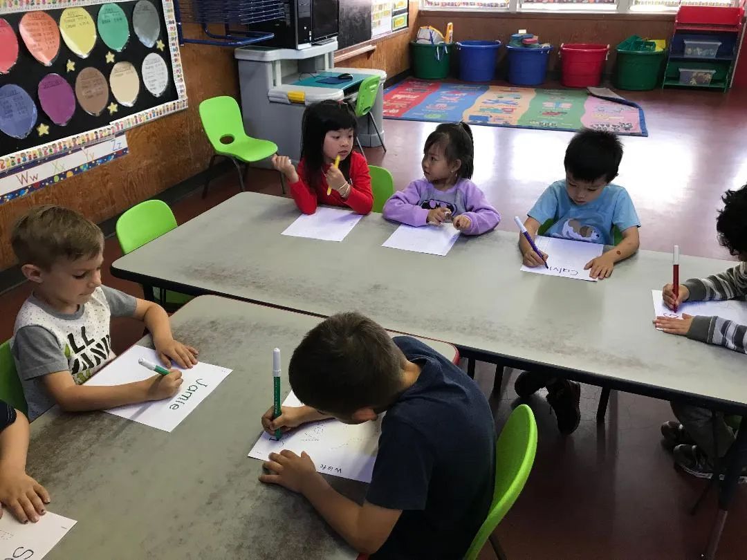 Students Writing on a Paper — Sacramento, CA — Tot Town Child Development Center, Inc.