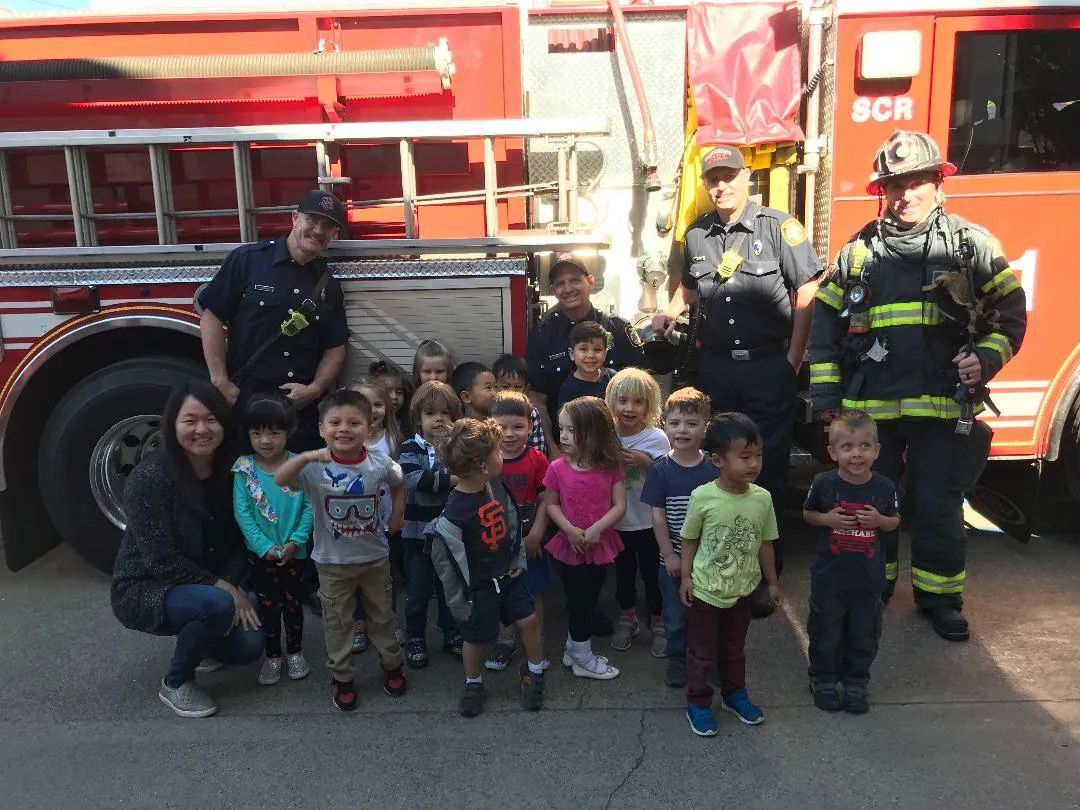 Happy Students and Firemen — Sacramento, CA — Tot Town Child Development Center, Inc.