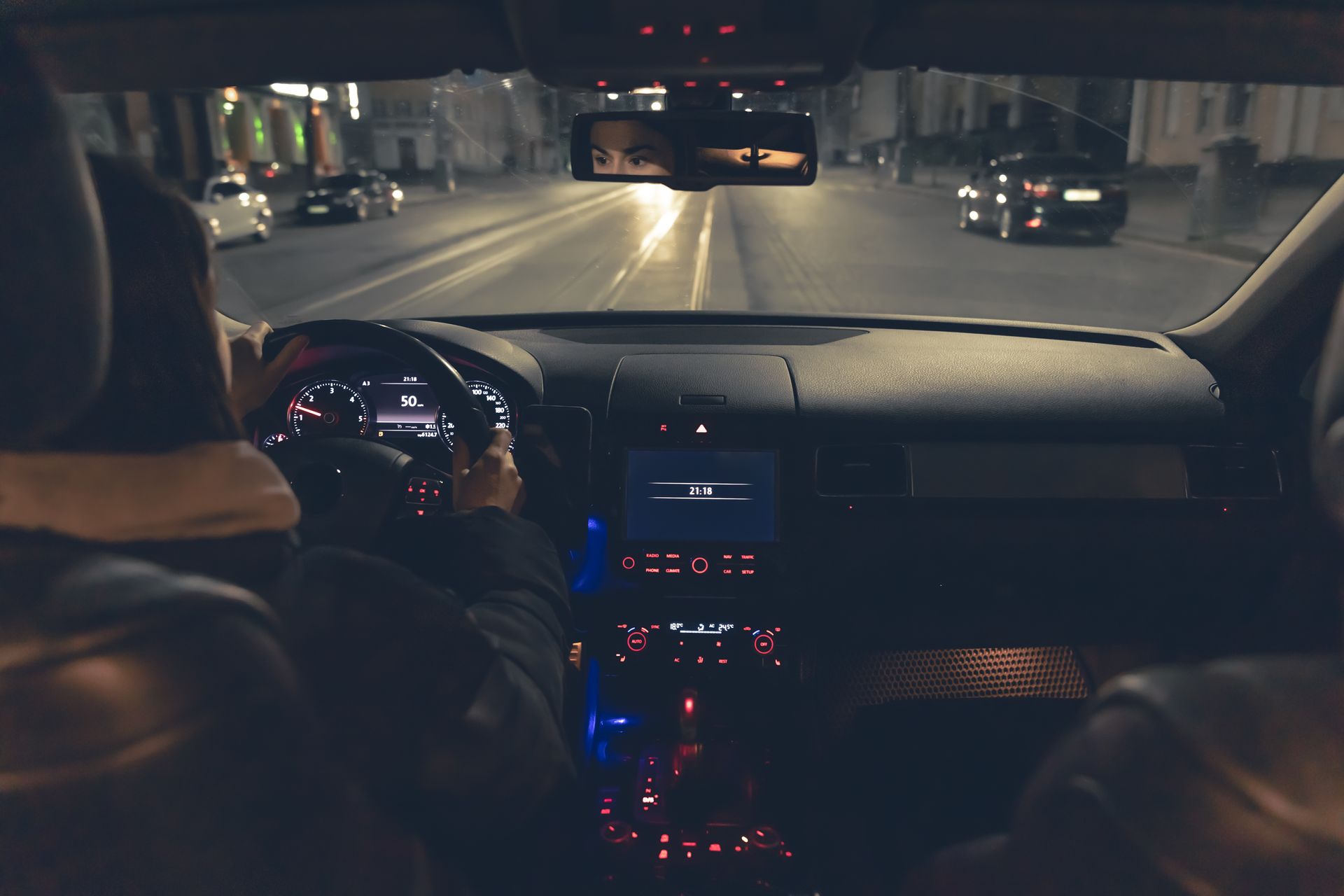 Person reaching into a car dashboard compartment with wiring exposed