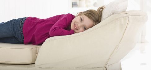Girl laying on clean white sofa cleaned by cleaning specialists in Latrobe Valley and West Gippsland
