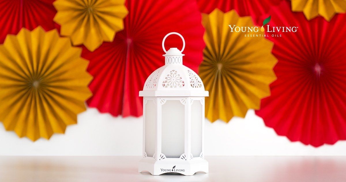 A white lantern is sitting in front of red and yellow paper fans