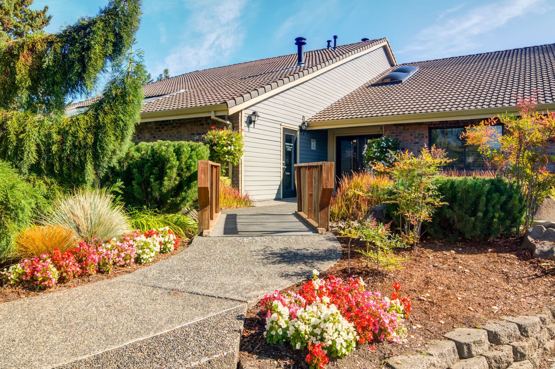 Entrance path to apartment building with landscaped garden and wooden railings at Ansley Murrayhill in Tigard, OR.