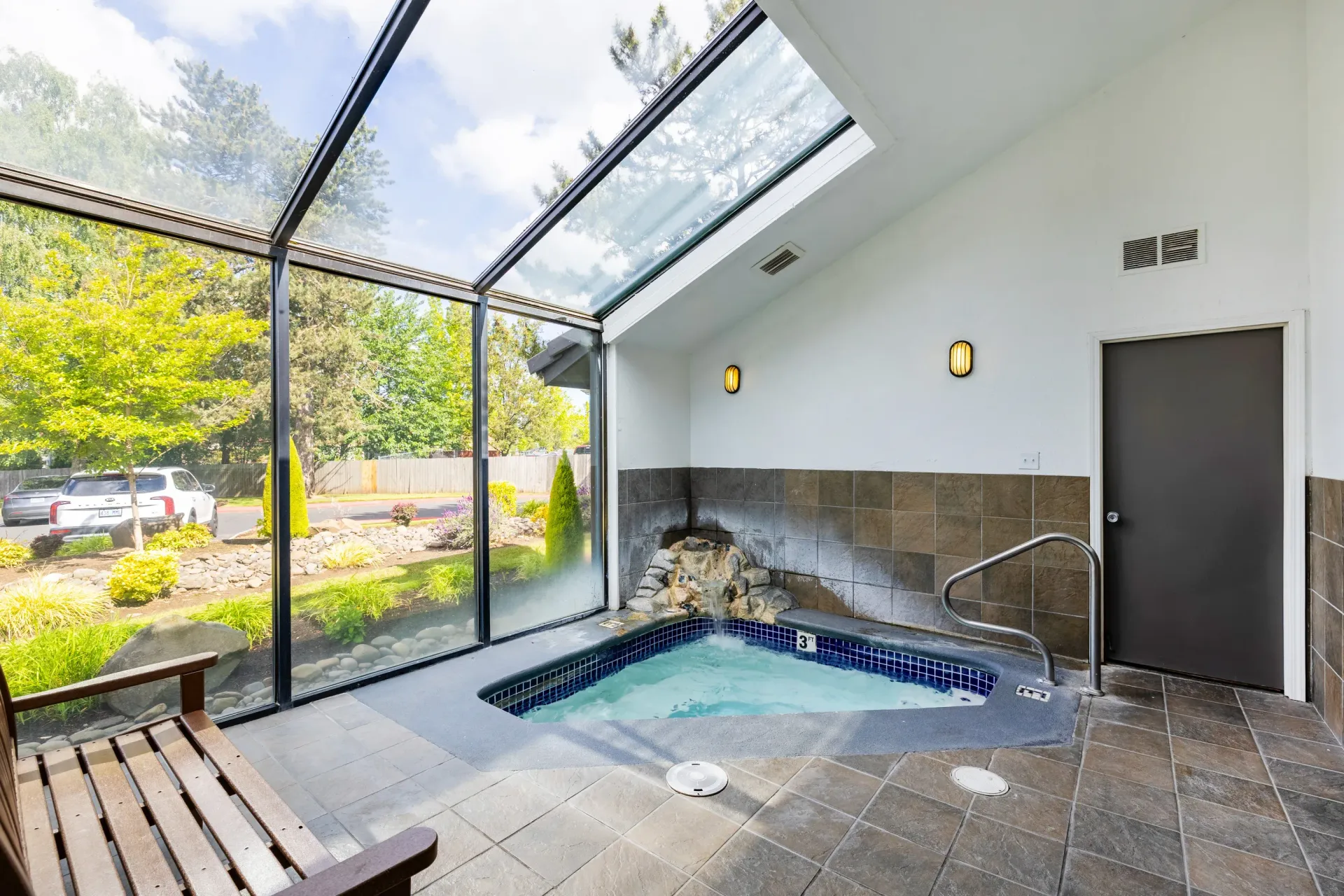 Glass-enclosed indoor pool and hot tub area with outdoor view at Ansley Murrayhill in Tigard, OR.