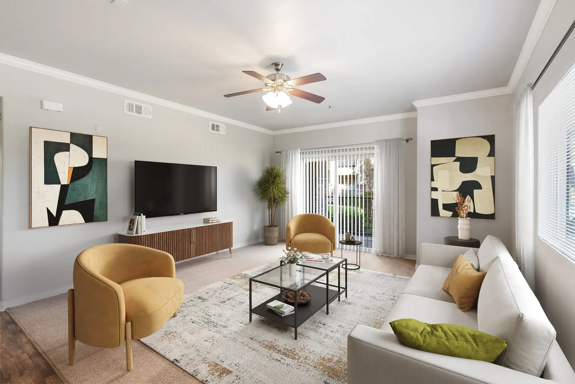 Modern apartment living room with a white sofa, mustard chairs, coffee table, TV, and large windows.