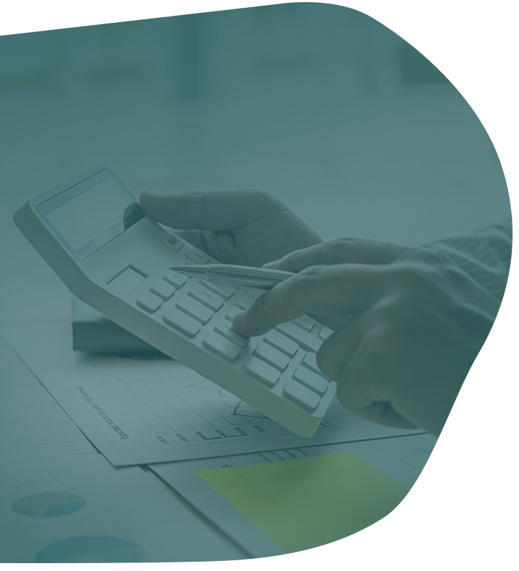 Hands using a calculator on a desk with papers and a sticky note, overlayed with a blue-green tint.