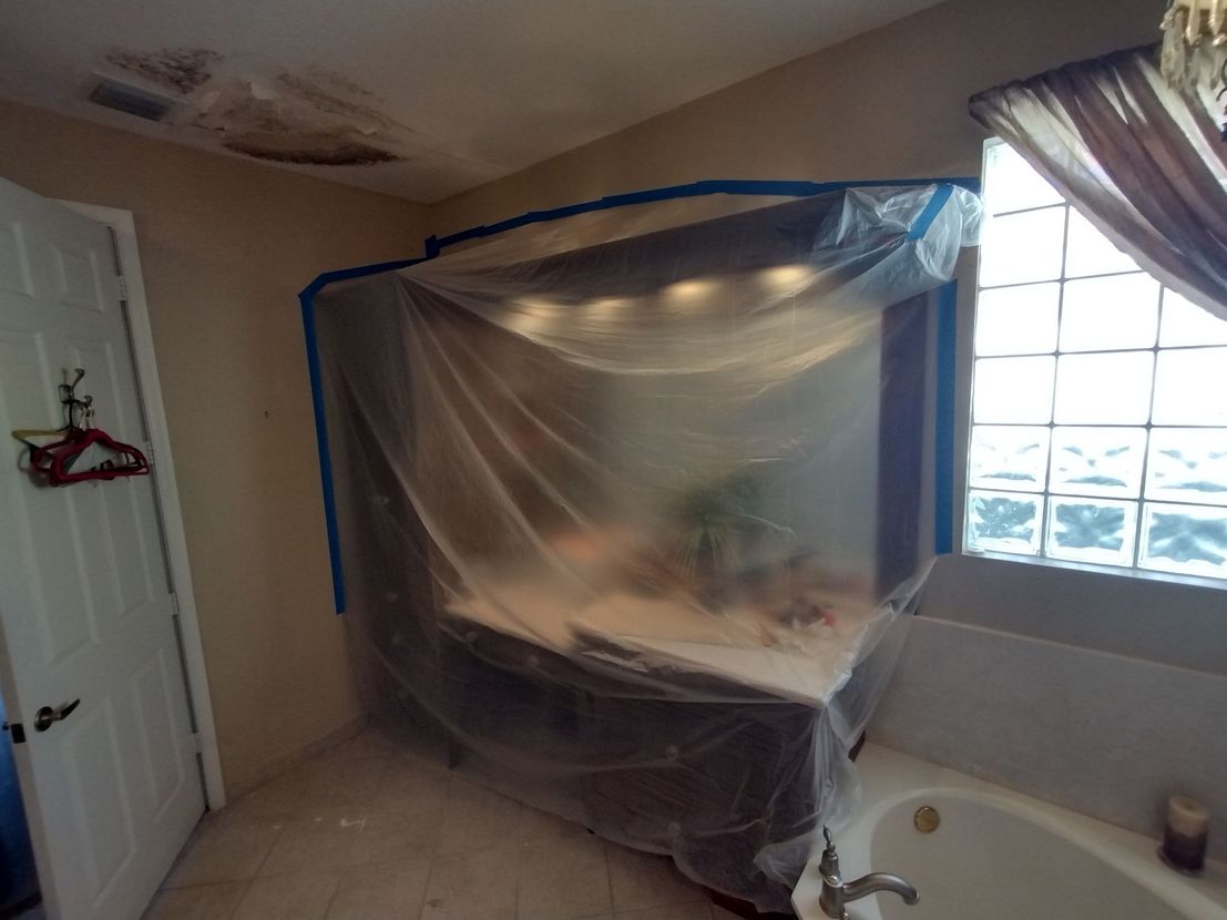 A bathroom with a vanity and tub covered in plastic
