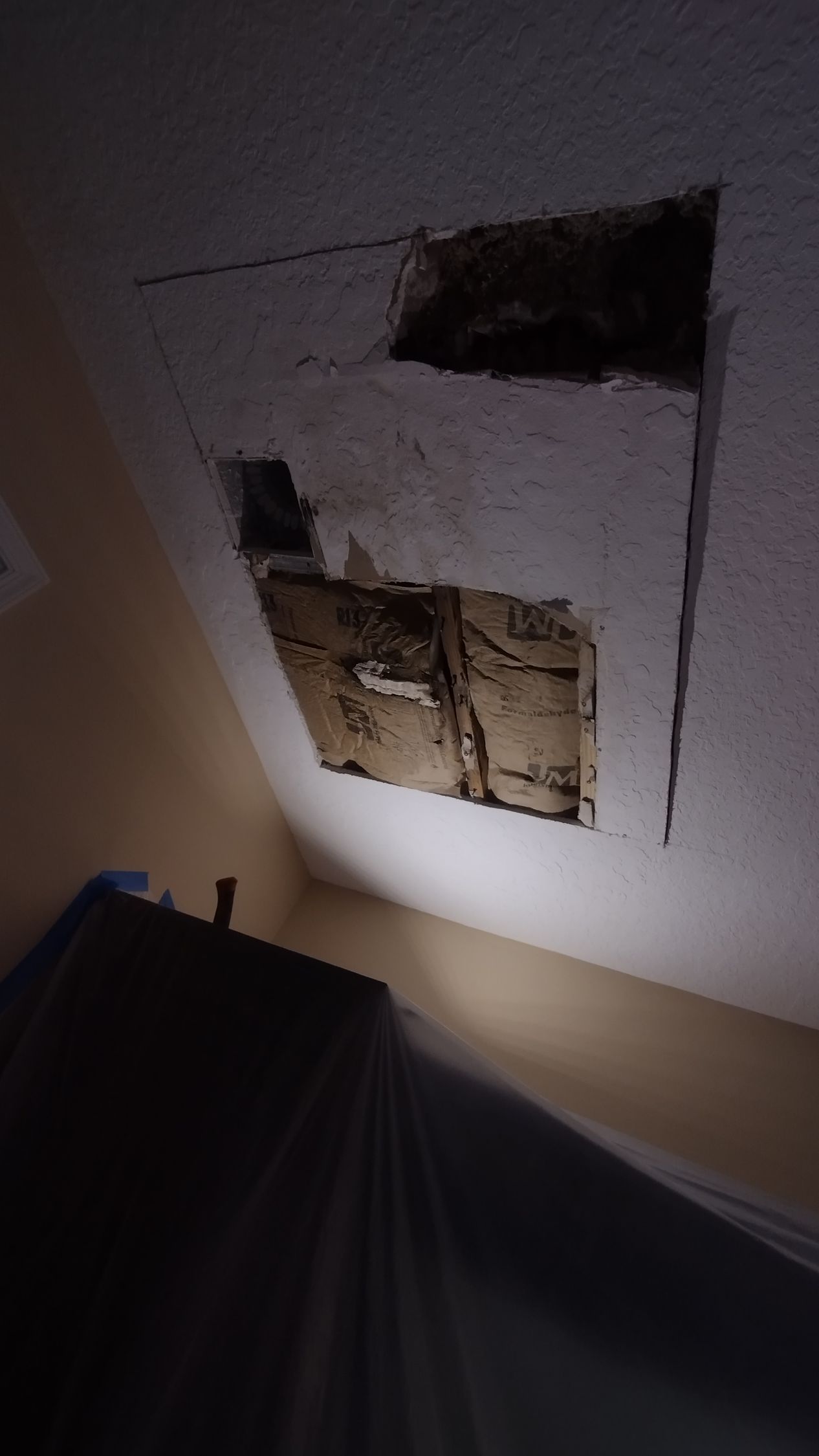 There is a hole in the ceiling in a room.