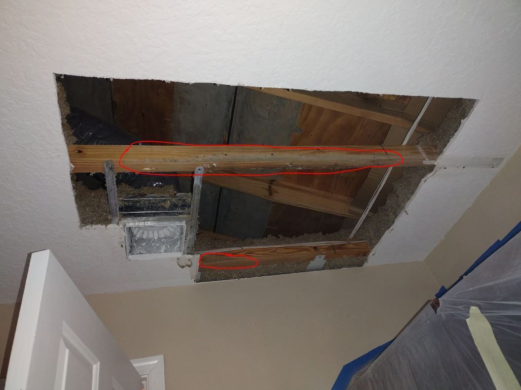 A hole in the ceiling in a room with a door