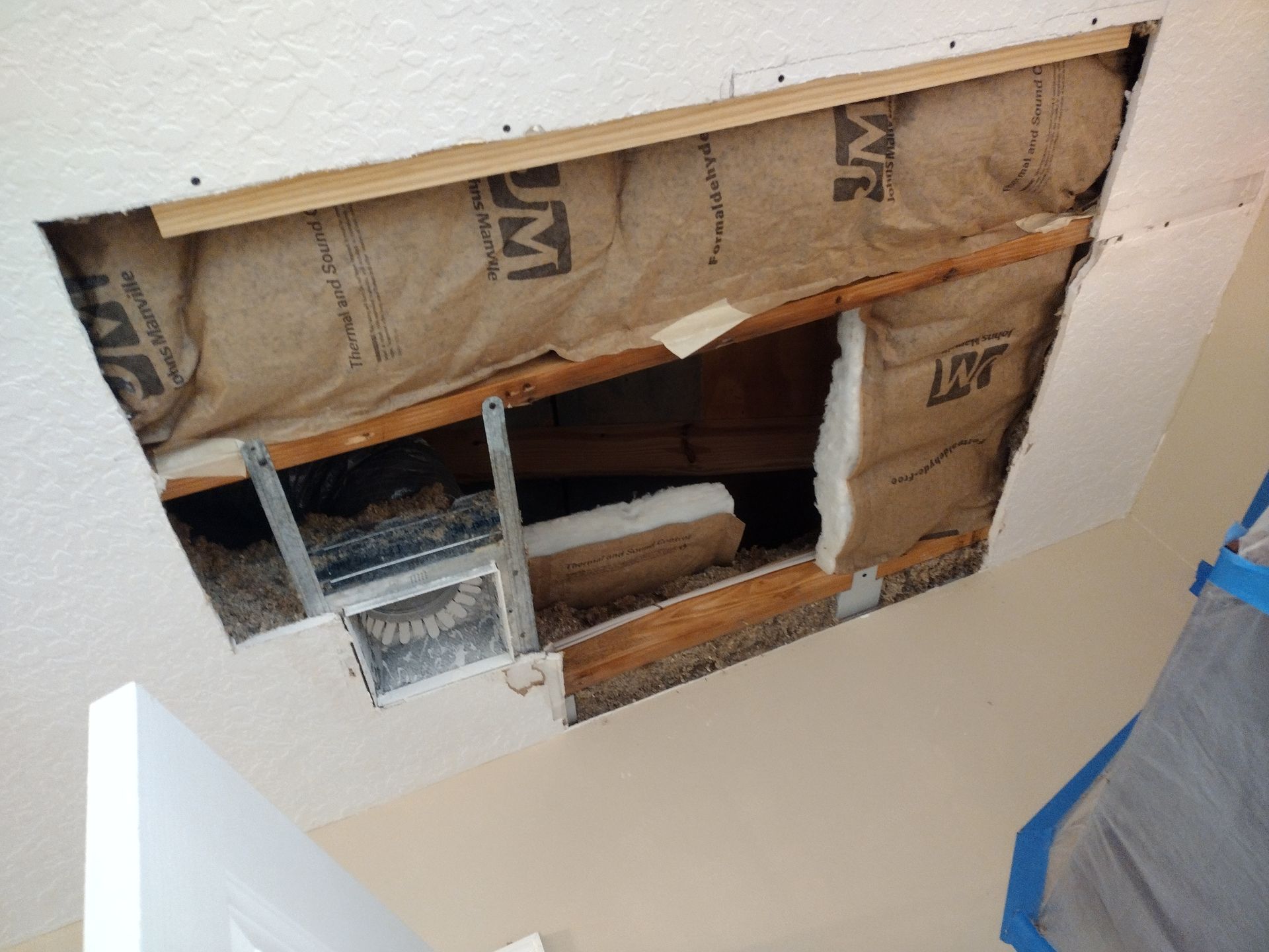 A hole in a wall with a bag that says lm on it