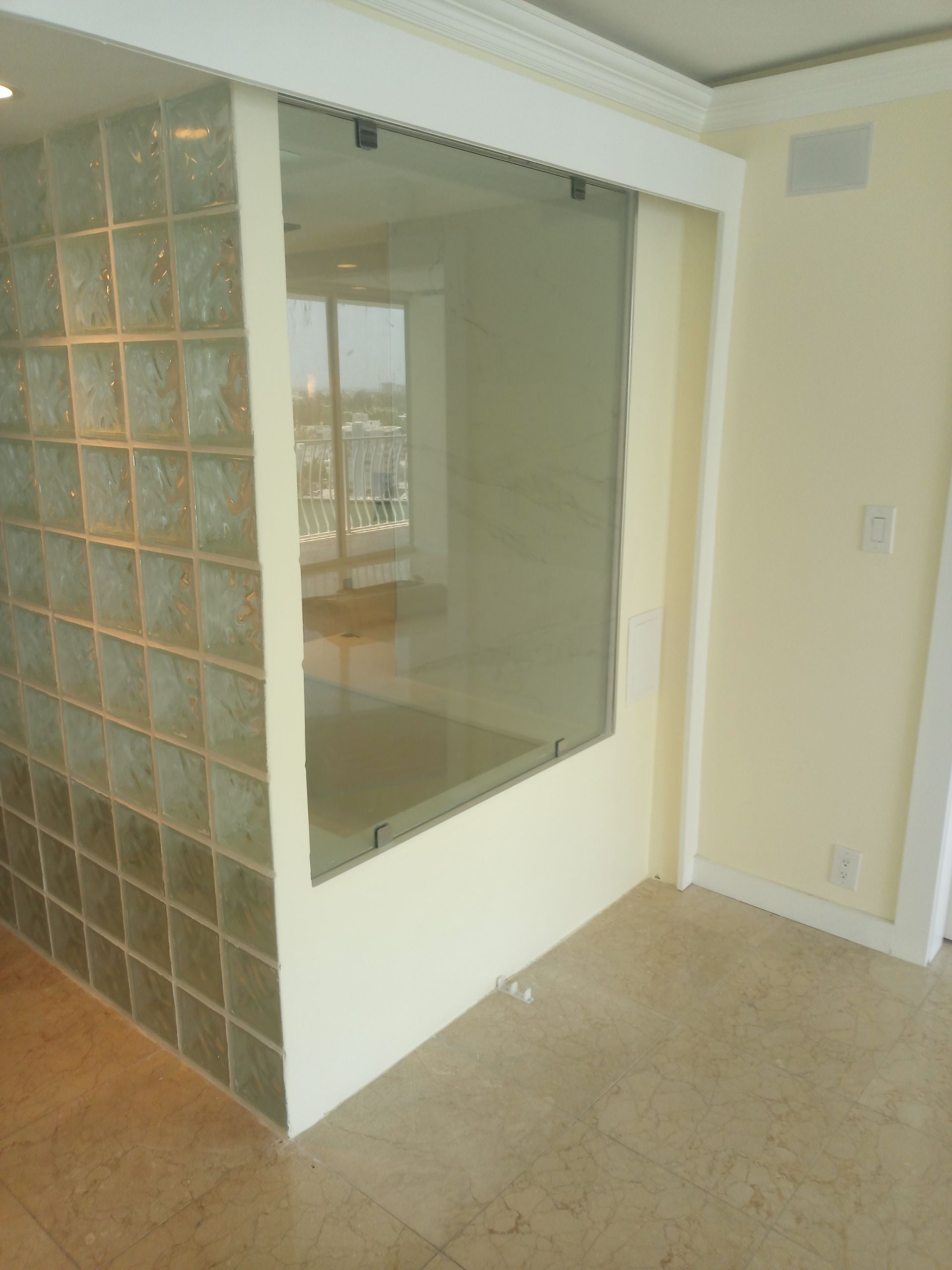 A room with a glass wall and a window