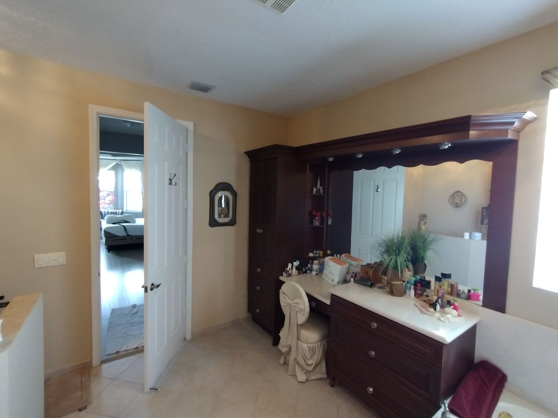 A bathroom with a large mirror and dresser
