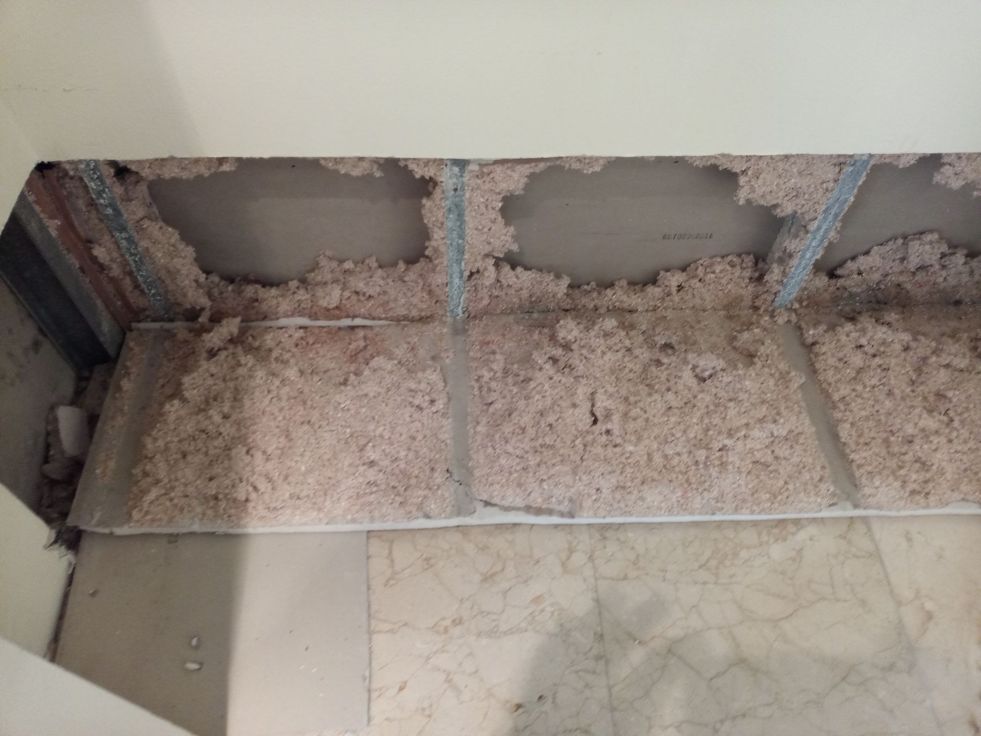 A ceiling with a lot of dust on it and a marble floor.